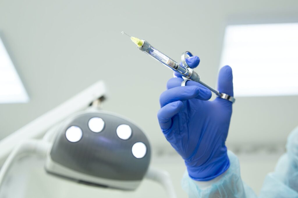 dentist hand in glove holding syringe